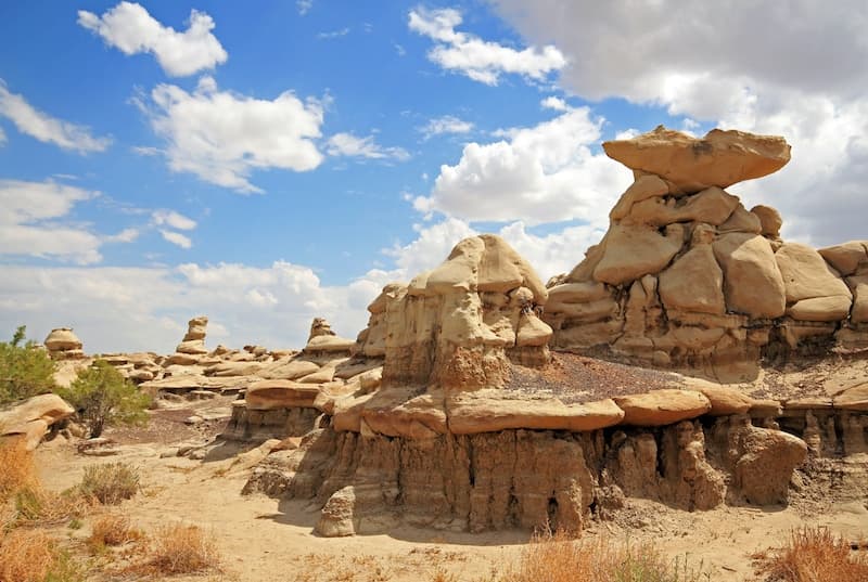 Rock formations under a blue sky with scattered clouds.