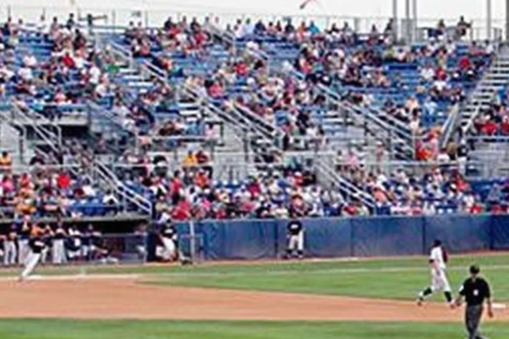 A crowded baseball stadium with fans in the stands watching a game.
